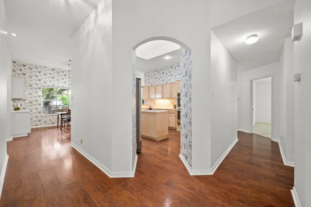 a view of a room with wooden floor kitchen view and a bathroom