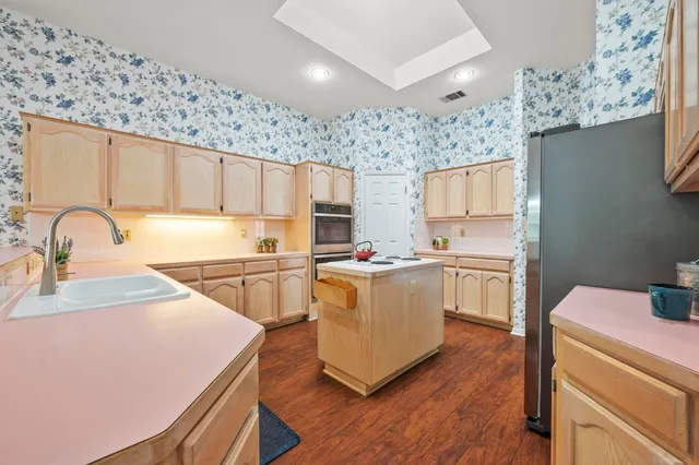 a kitchen with a sink cabinets and wooden floor