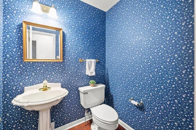 a bathroom with a toilet a sink and mirror