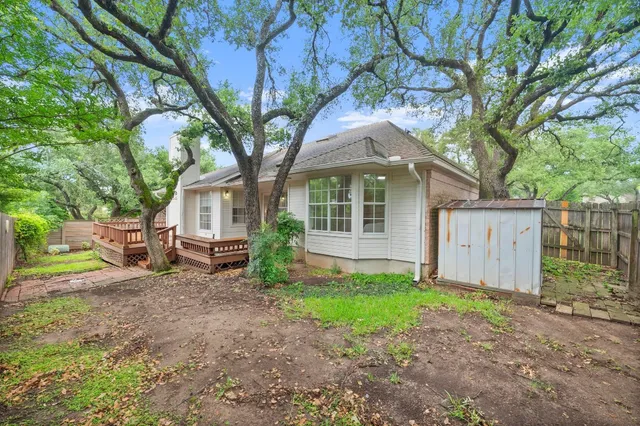 a front view of a house with garden and trees