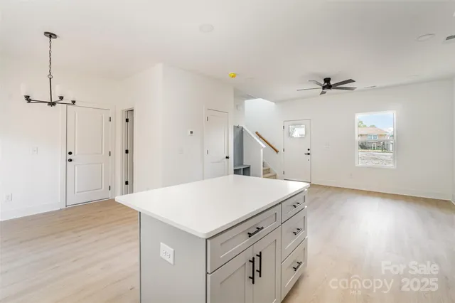 a kitchen with stainless steel appliances a stove a microwave and white cabinets