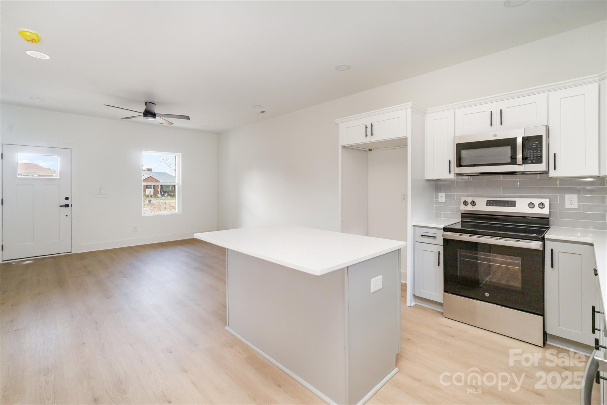 604 6th St Court Northwest Conover, NC 28613 - Photo 15 of 31 a kitchen with stainless steel appliances a stove a microwave and white cabinets