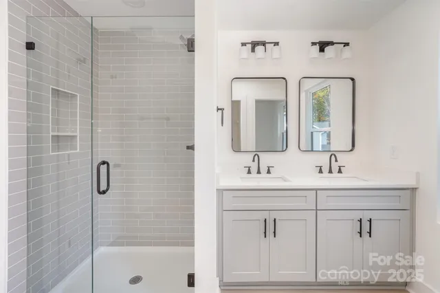 a bathroom with double vanity sinks and a mirror