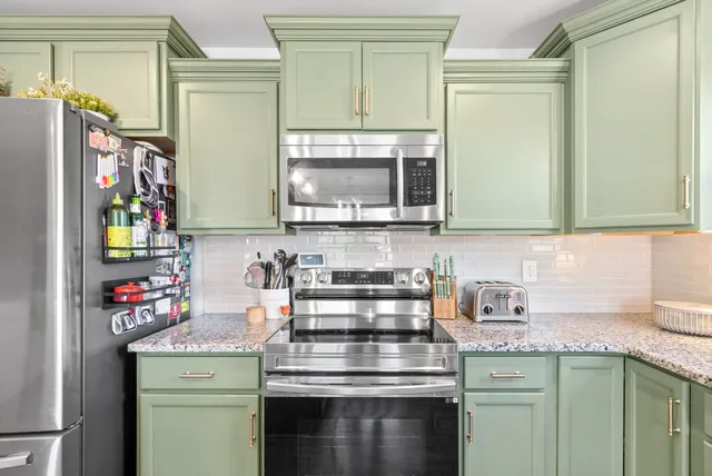 a kitchen with granite countertop a stove a sink and a microwave