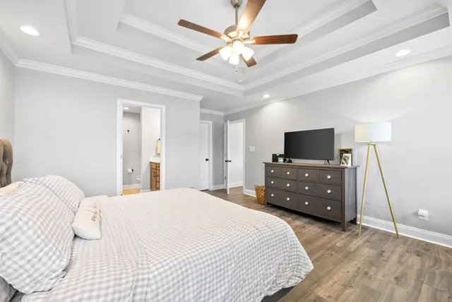 a bedroom with a bed and a flat tv screen on dresser
