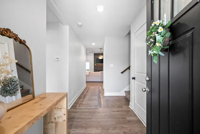 a hallway with a potted plant on the counter and a mirror