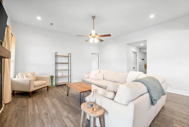 a living room with furniture and a wooden floor