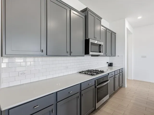 a kitchen with stainless steel appliances a sink stove and cabinets