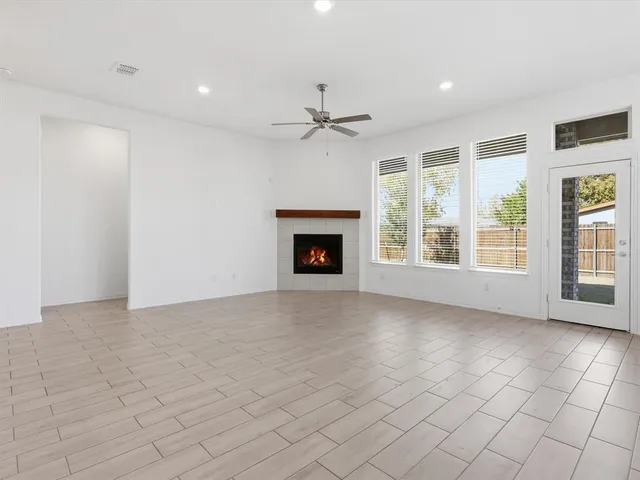 an empty room with windows and fireplace