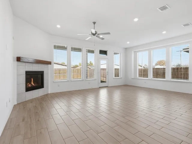 an empty room with windows and fireplace