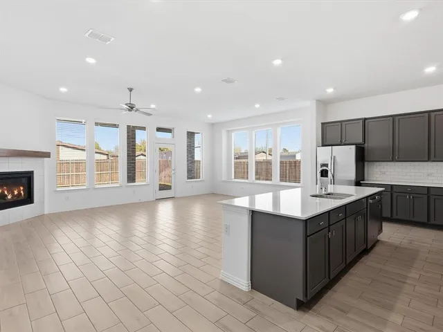 a large kitchen with stainless steel appliances granite countertop a large counter top a stove and a sink