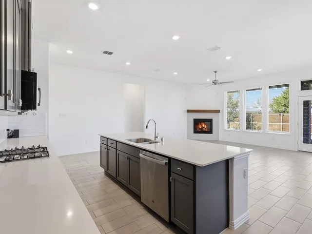 a kitchen with stainless steel appliances granite countertop a sink a stove and a refrigerator