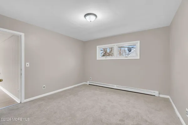an empty room with a ceiling fan and window