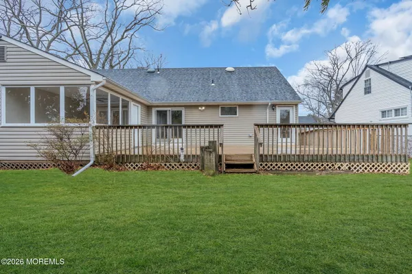 a view of a house with a yard and deck