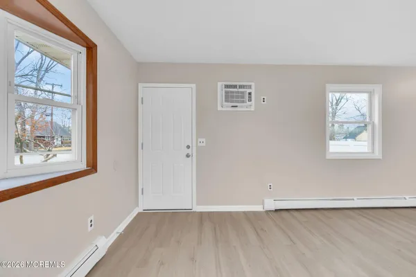 a view of an empty room with a painting on the wall and a window