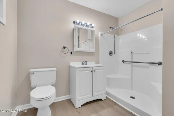 a bathroom with a shower sink vanity mirror and toilet