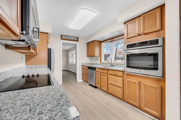 a kitchen with stainless steel appliances kitchen island granite countertop a stove top oven a sink and dishwasher