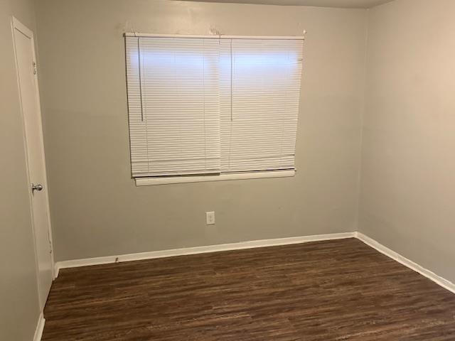 3268 Powell Avenue Memphis, TN 38112 - Photo 2 of 5 Spare room featuring baseboards and dark wood finished floors