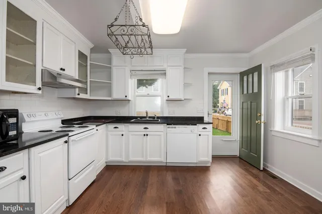 a kitchen with stainless steel appliances granite countertop a sink a stove a refrigerator and cabinets