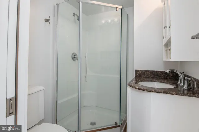 a bathroom with a granite countertop sink mirror and toilet