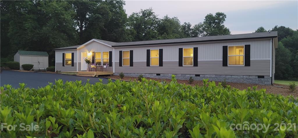 a front view of a house with yard and green space