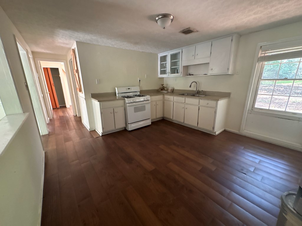 2910 Beech Street Columbus, GA 31909 - Photo 7 of 24 a kitchen with granite countertop a sink cabinets and wooden floor