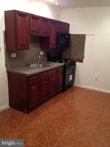 a kitchen with stainless steel appliances granite countertop a sink cabinets and wooden floor