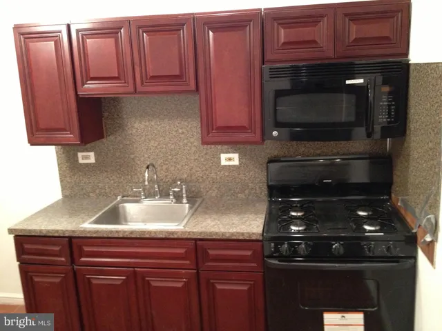 a kitchen with granite countertop a sink stainless steel appliances and cabinets