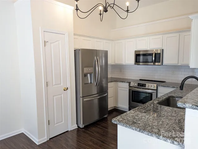 a kitchen with granite countertop a sink and steel appliances