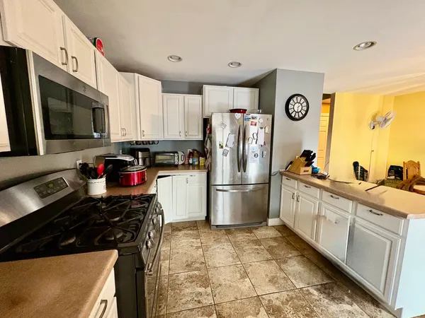a kitchen with a refrigerator and a stove top oven