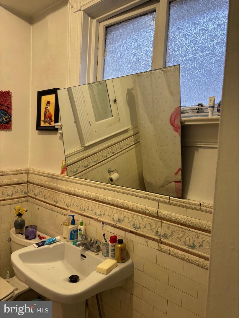 259 South 46th Street, Unit 2F Philadelphia, PA 19139 - Photo 12 of 14 a bathroom with a sink and a mirror