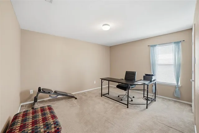 a view of a workspace with furniture and a window
