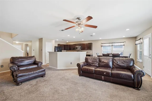 a living room with furniture and kitchen view