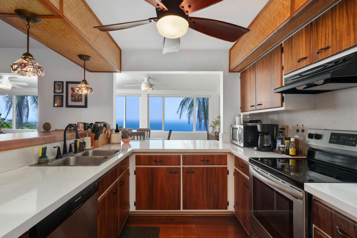 85-4563 Hawaii Belt Road Captain Cook, HI 96704 - Photo 8 of 30 a kitchen with stainless steel appliances a sink stove and cabinets