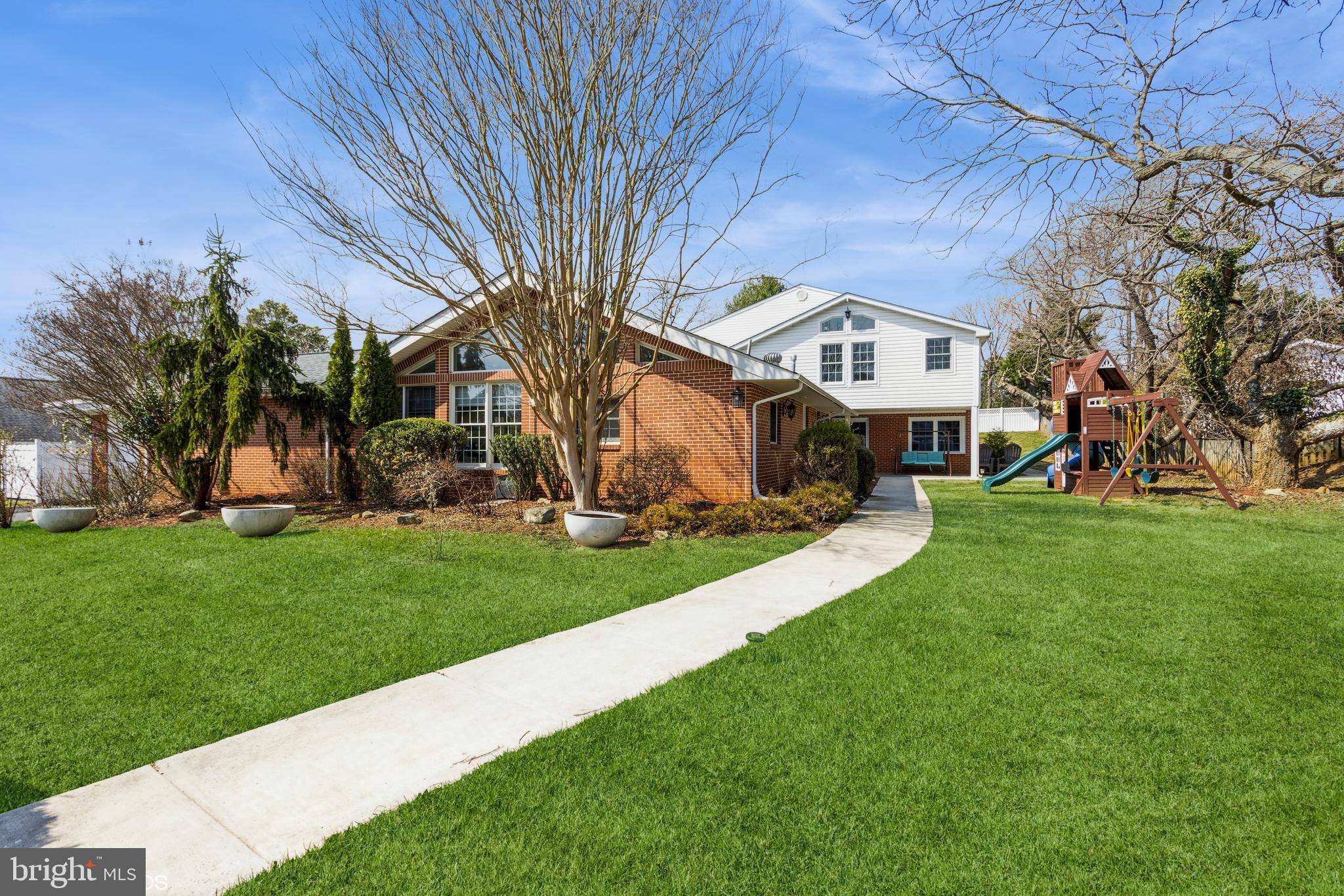 a view of a house with a big yard and large trees