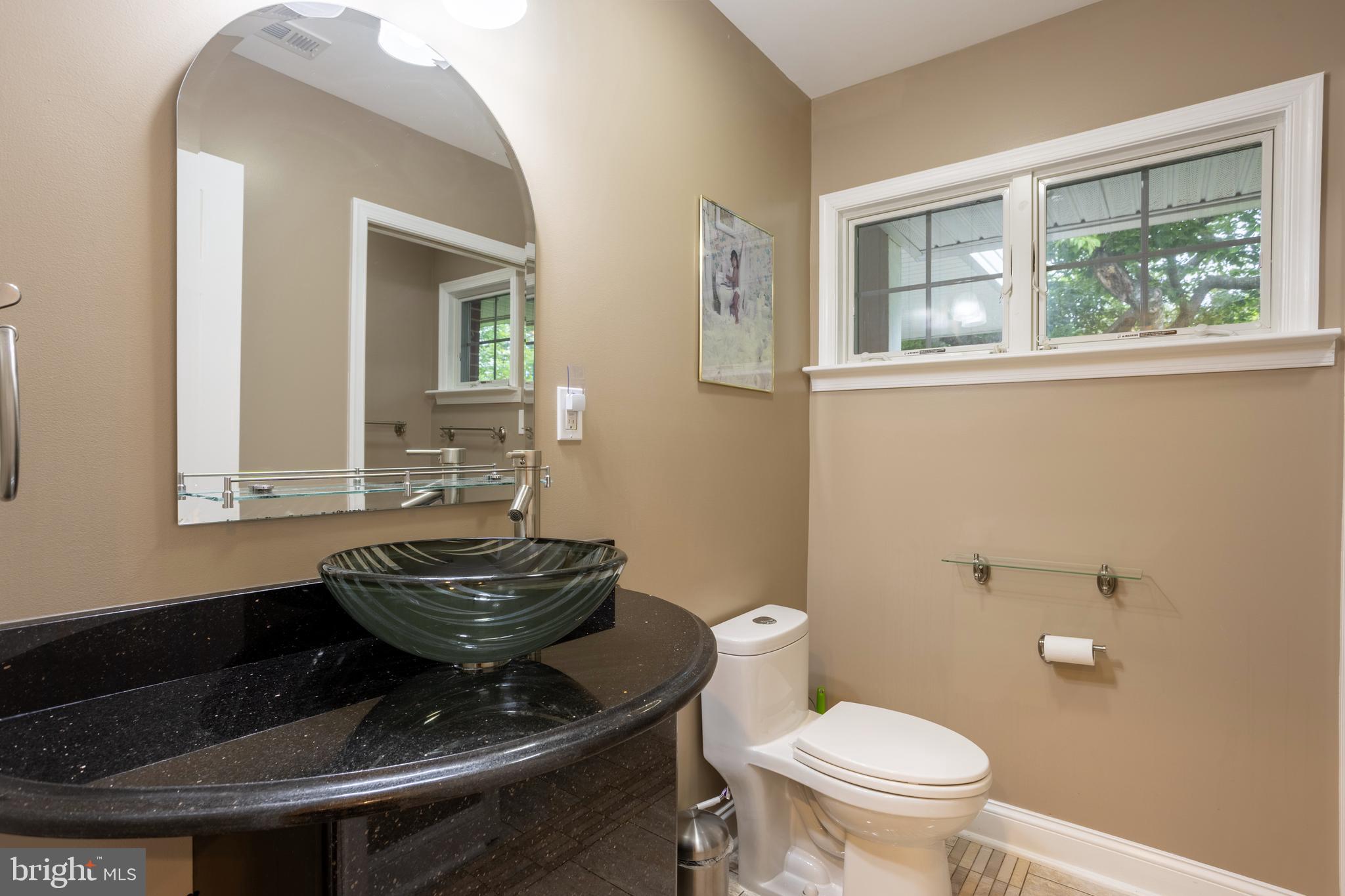 7908 Ivy Lane Baltimore, MD 21208 - Photo 30 of 90 a bathroom with a toilet a sink and a mirror