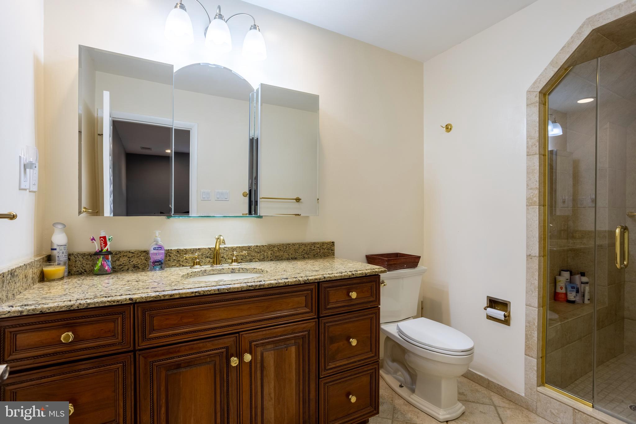 7908 Ivy Lane Baltimore, MD 21208 - Photo 35 of 90 a bathroom with a granite countertop toilet sink and a mirror