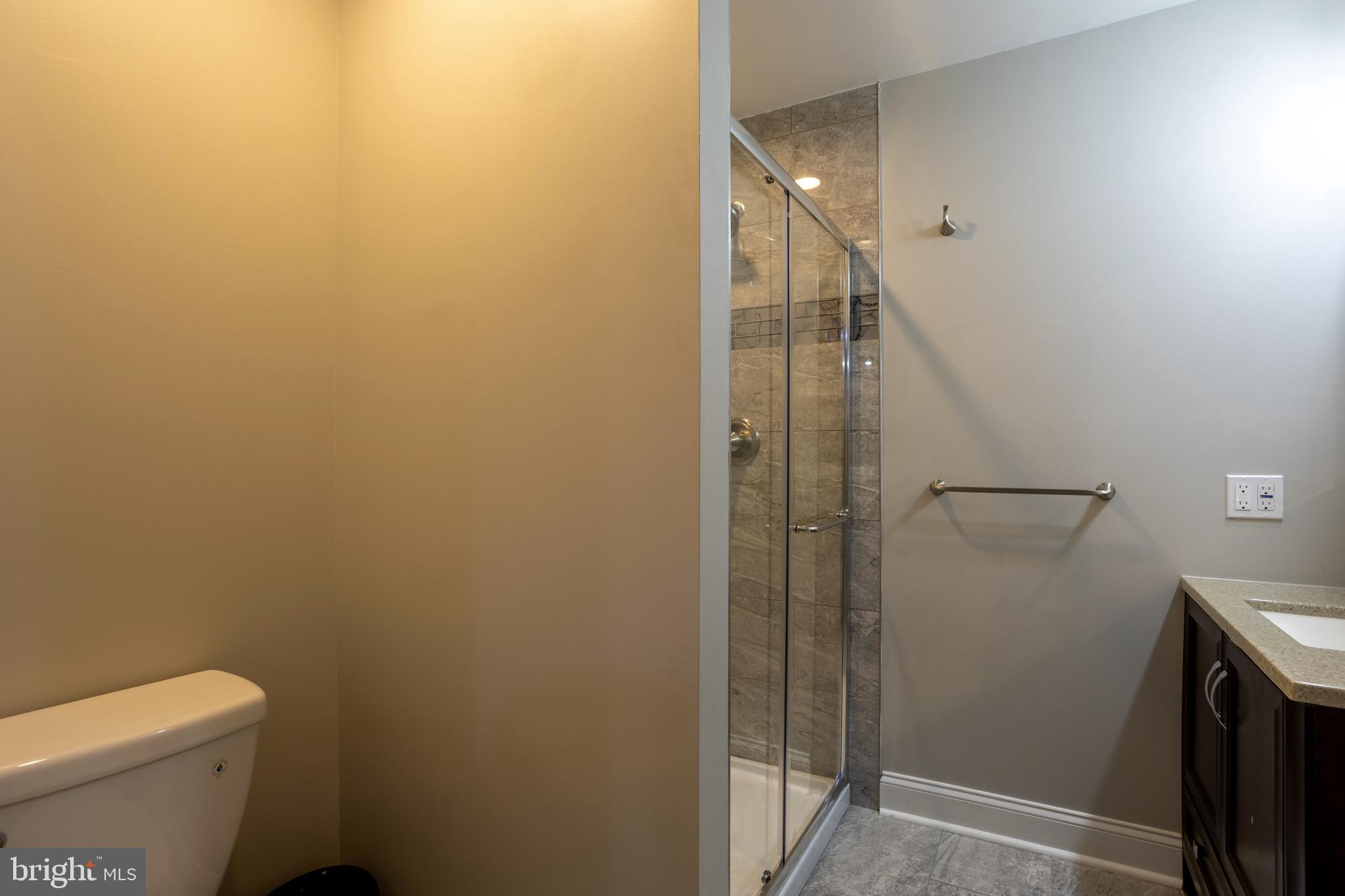 7908 Ivy Lane Baltimore, MD 21208 - Photo 60 of 90 a bathroom with a granite countertop shower and a toilet