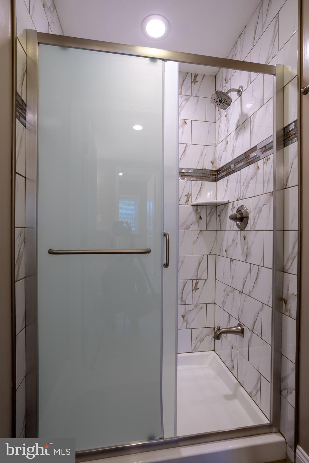 7908 Ivy Lane Baltimore, MD 21208 - Photo 67 of 90 a bathroom with a glass shower door