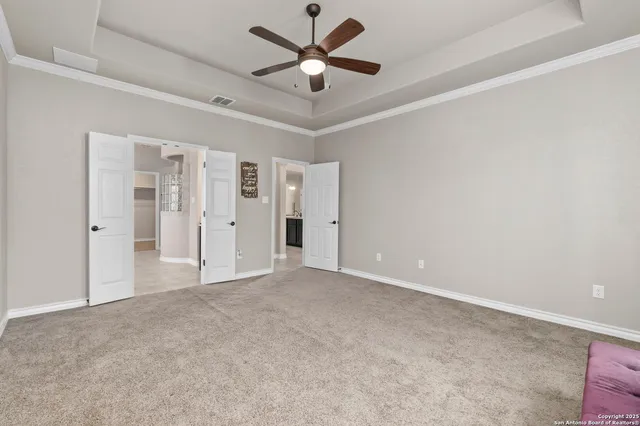 an empty room with closet and a ceiling fan