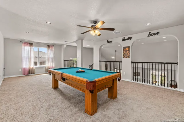 a room with pool table and windows