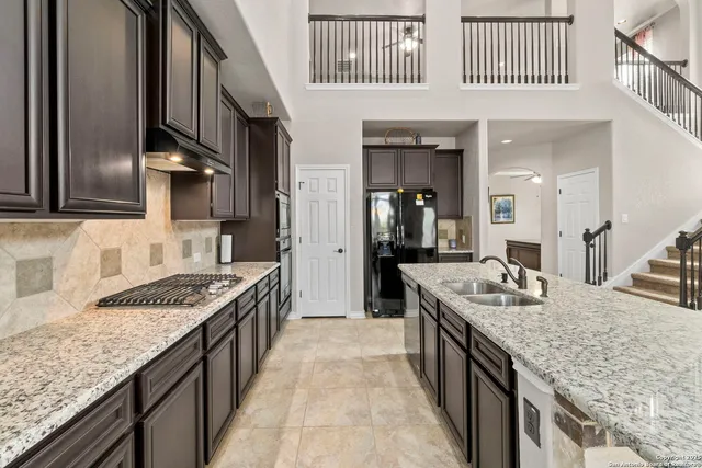 a kitchen with stainless steel appliances granite countertop a sink stove and cabinets