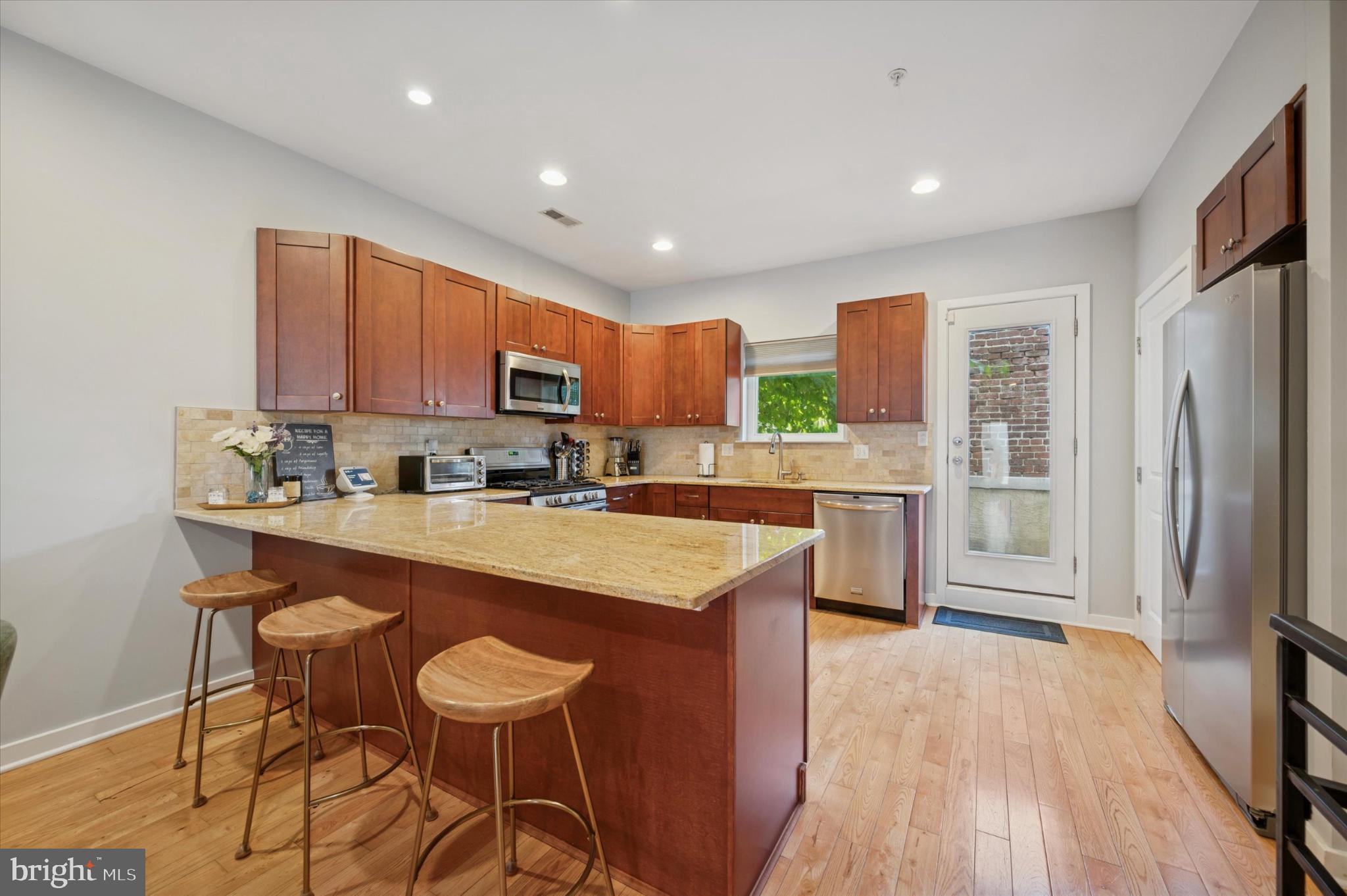 4128 Apple Street Philadelphia, PA 19127 - Photo 7 of 25 a kitchen with stainless steel appliances granite countertop a table chairs refrigerator and a sink