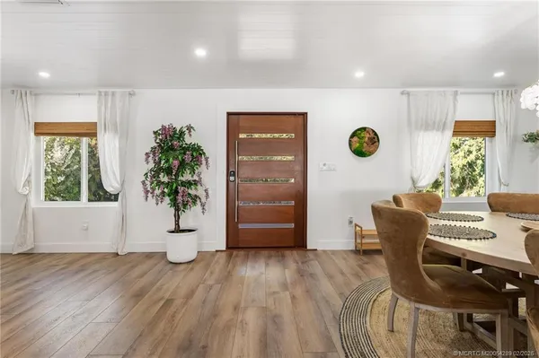 a dining room with lots of wooden furniture and a view of kitchen