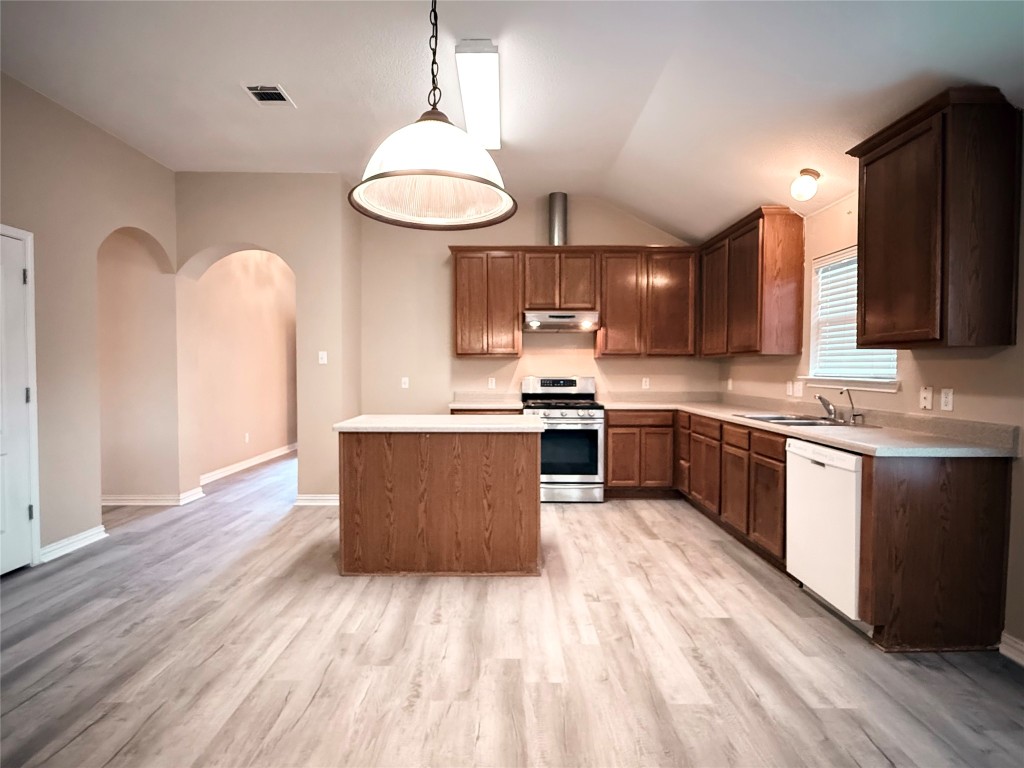 1548 Tonia Loop Round Rock, TX 78665 - Photo 12 of 29 a large kitchen with stainless steel appliances kitchen island granite countertop a stove a sink dishwasher and a refrigerator with wooden floor