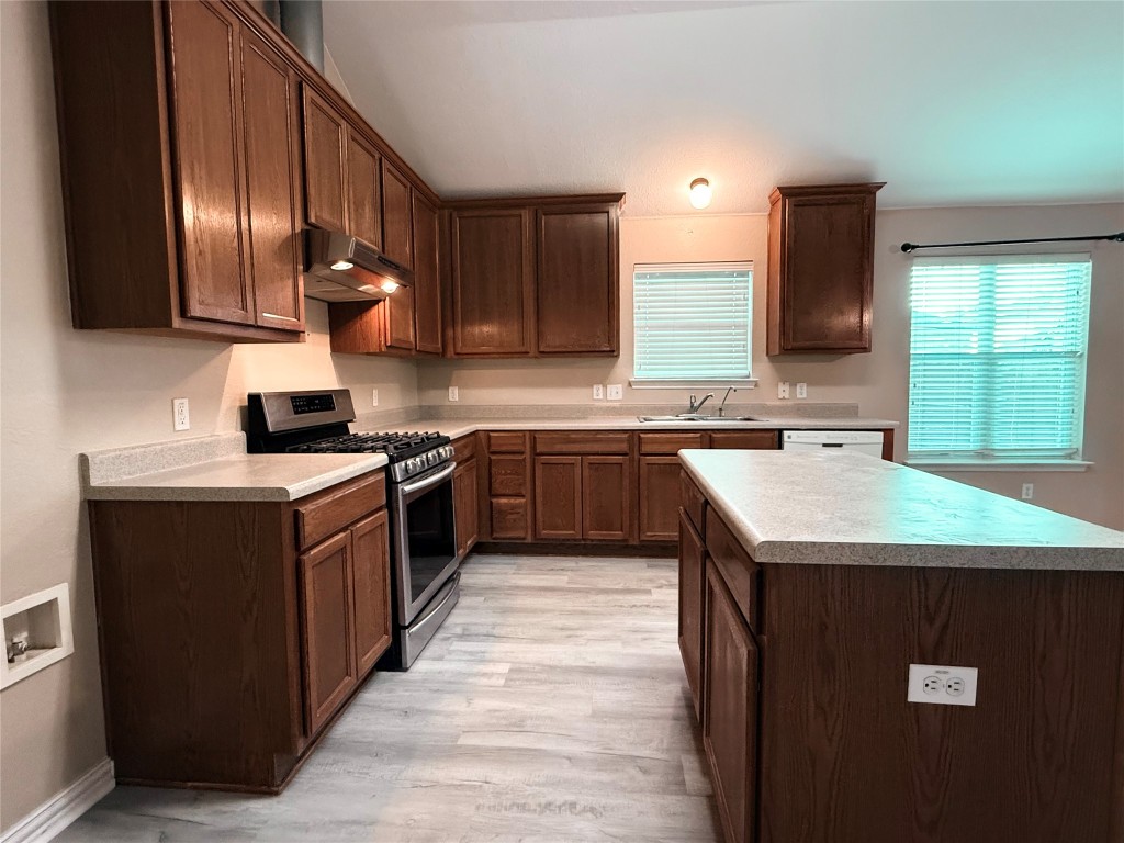 1548 Tonia Loop Round Rock, TX 78665 - Photo 17 of 29 a kitchen with a sink dishwasher a stove top oven a refrigerator with island and cabinets