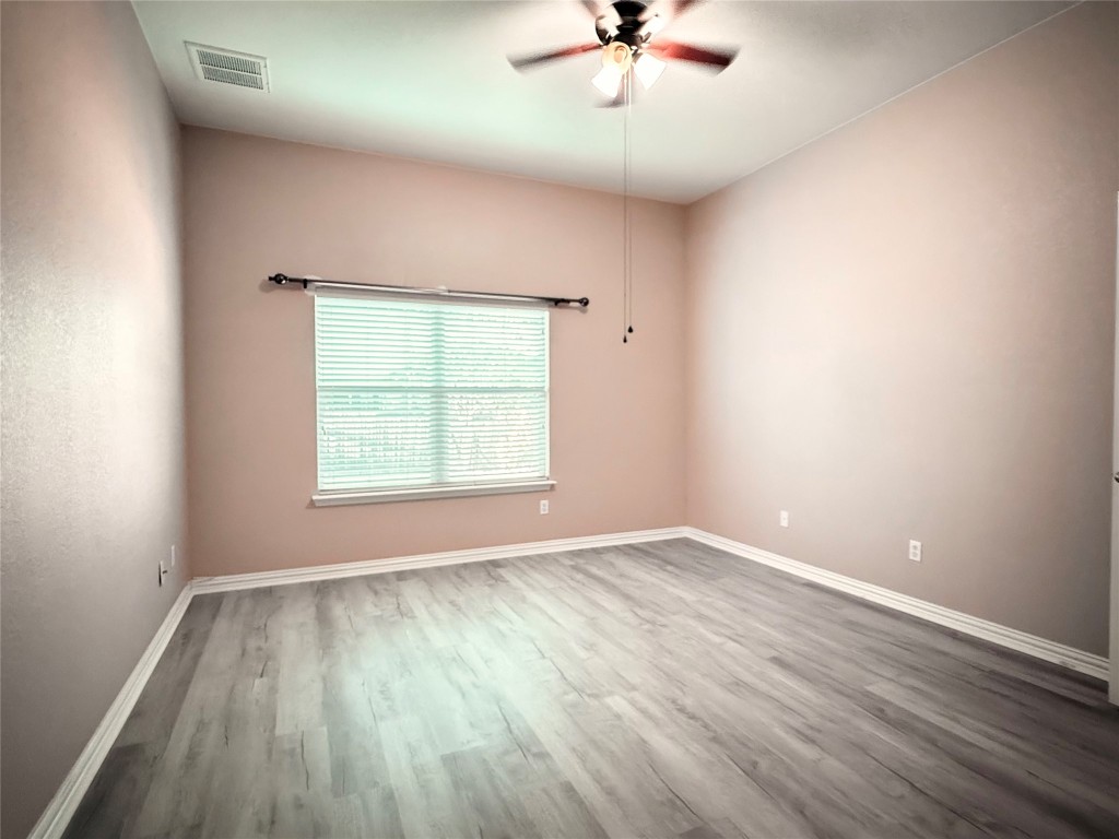 1548 Tonia Loop Round Rock, TX 78665 - Photo 28 of 29 an empty room with wooden floor chandelier fan and windows