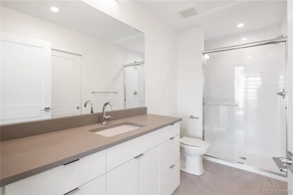 a bathroom with a granite countertop sink toilet and shower