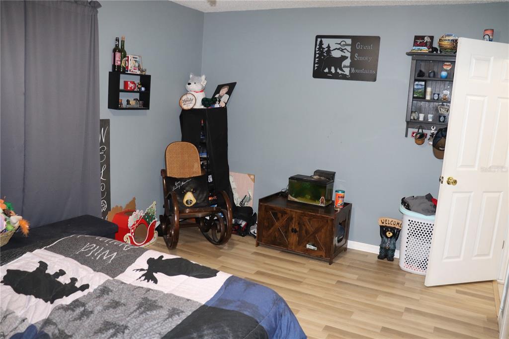 12387 Seagate Street Spring Hill, FL 34609 - Photo 19 of 51 a bedroom with a bed and wooden floor