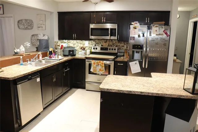 a kitchen with a sink refrigerator and microwave